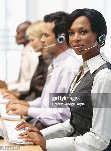 side profile of four business executives wearing headsets and sitting in a row - communication occupation stock pictures, royalty-free photos & images