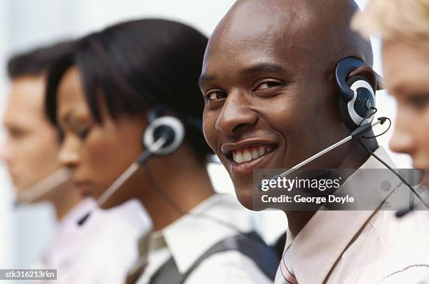 side profile of four business executives wearing headsets in an office - communication occupation stock pictures, royalty-free photos & images