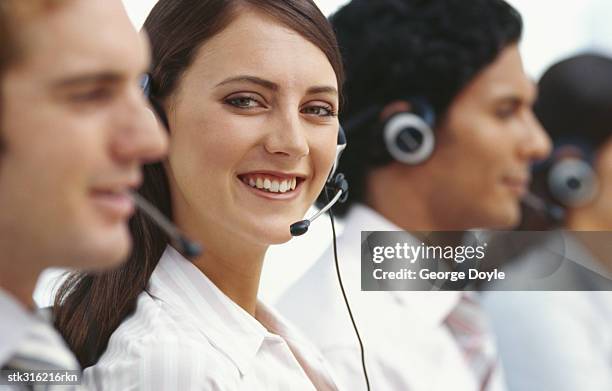 side profile of four business executives wearing headsets in an office - communication occupation stock pictures, royalty-free photos & images