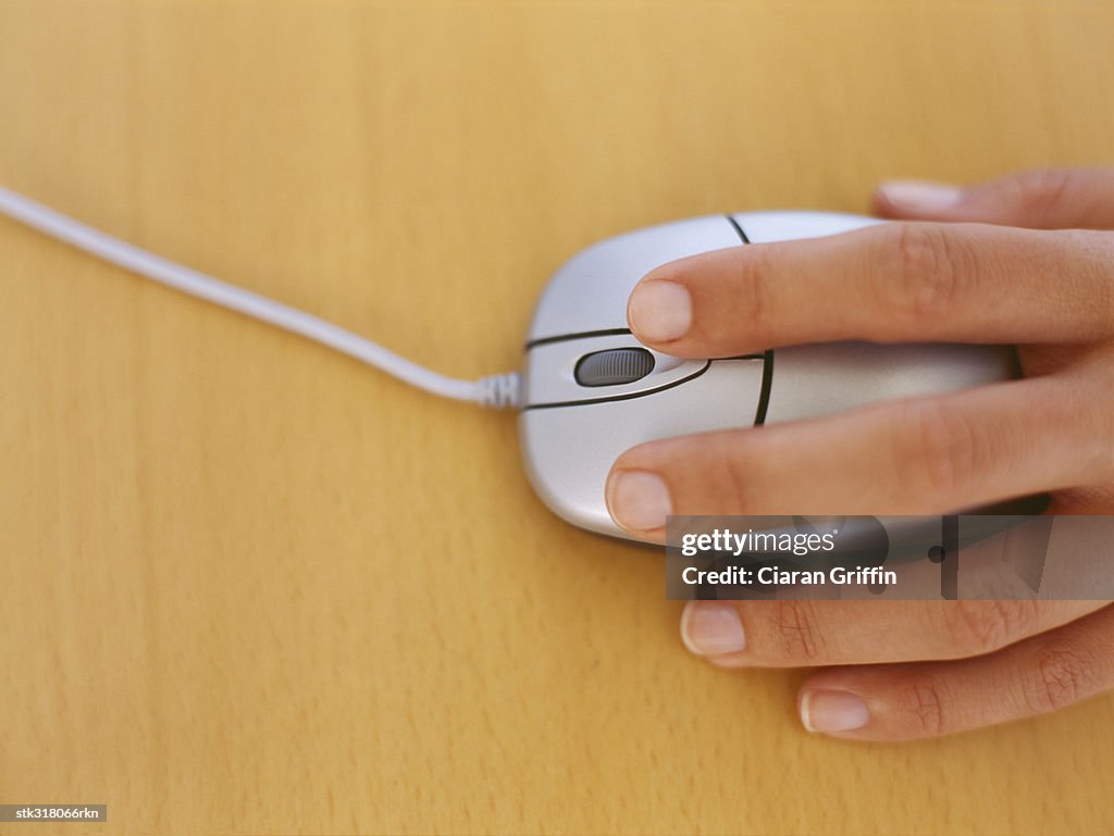 High angle view of a human hand holding a computer mouse