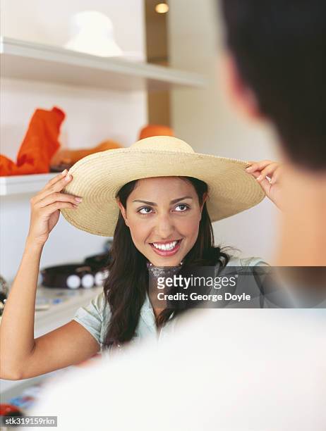 young woman holding a hat - hat stock-fotos und bilder