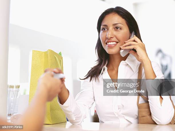 young woman making payment through a credit card - retail equipment stock pictures, royalty-free photos & images