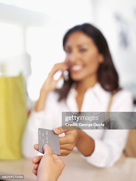 young woman making payment through a credit card - equipamento de varejo - fotografias e filmes do acervo