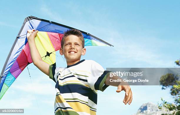 low angle view of a boy playing with a kite - human limb stock pictures, royalty-free photos & images