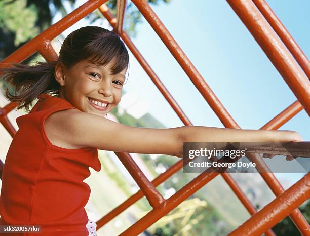 side profile of a girl hanging on monkey bars - wonky fringe stock pictures, royalty-free photos & images