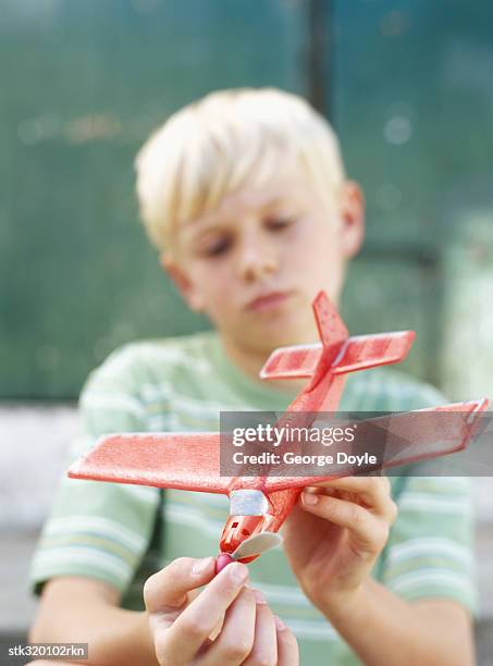 close-up of a boy playing with a toy airplane - modell stock pictures, royalty-free photos & images