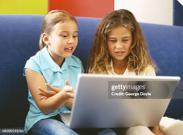 two girls using a laptop - unveiling of life size statue of andrea bocelli at keep memory alive event center stockfoto's en -beelden