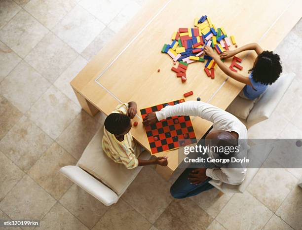 high angle view of a father playing with his two sons - black man high 5 stockfoto's en -beelden