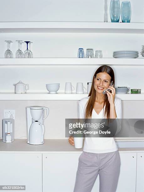 businesswoman talking on a mobile phone in the kitchen - the kitchen bildbanksfoton och bilder