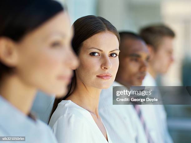 four business executives standing next to each other in an office - next stockfoto's en -beelden