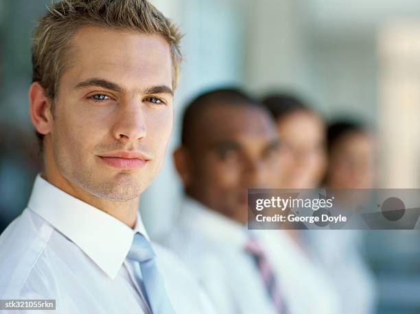 portrait of four business executives standing next to each other - next stockfoto's en -beelden