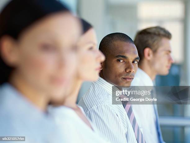 side profile of business executives standing together in an office - african american woman profile serious stock pictures, royalty-free photos & images