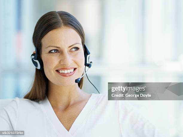 businesswoman wearing a headset in an office - kommunikationsberuf stock-fotos und bilder