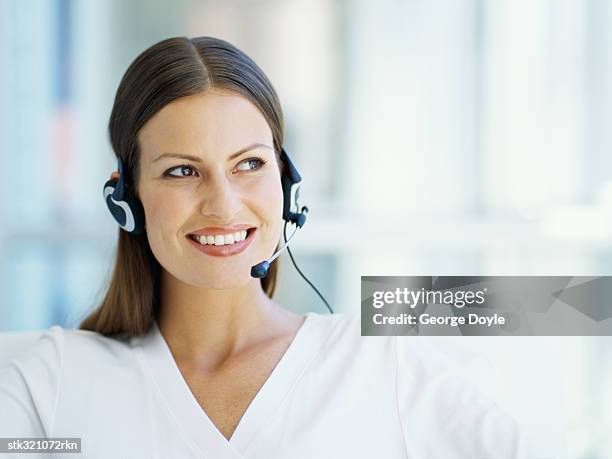 businesswoman wearing a headset in an office - communication occupation stock pictures, royalty-free photos & images