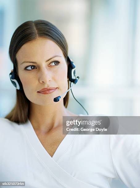 businesswoman wearing a headset in an office - communication occupation stock pictures, royalty-free photos & images