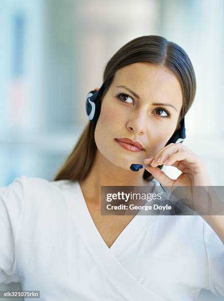 businesswoman wearing a headset in an office - communication occupation stock pictures, royalty-free photos & images