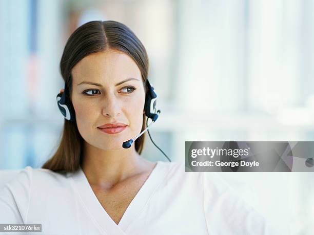 businesswoman wearing a headset in an office - occupazione nella comunicazione foto e immagini stock