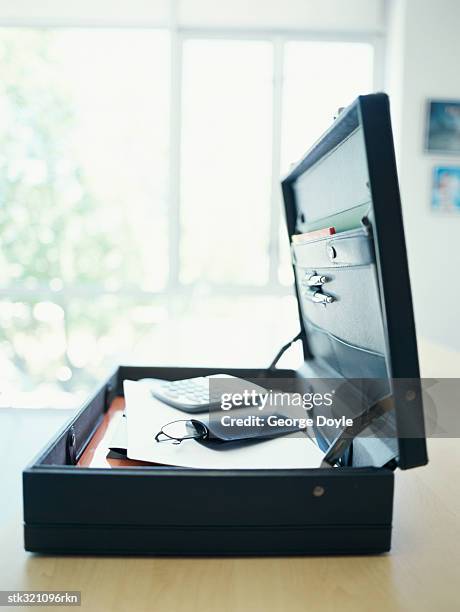 open briefcase lying on a table in an office - instrumento de contar fotografías e imágenes de stock