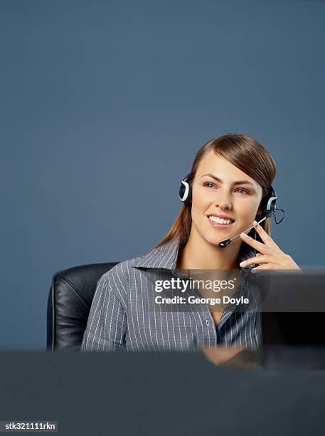 businesswoman wearing a headset in an office - communication occupation stock pictures, royalty-free photos & images