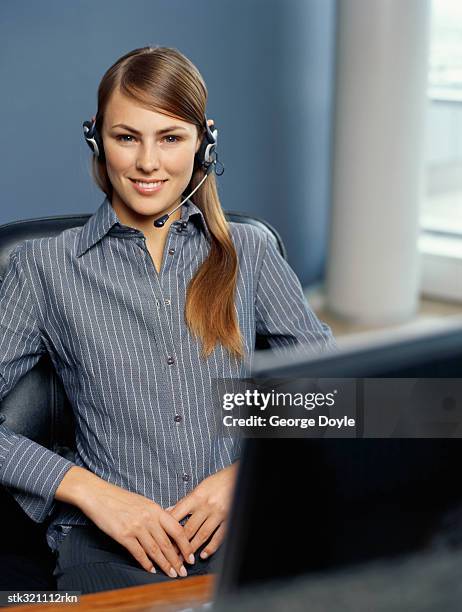 portrait of a businesswoman wearing a headset in an office - métier de la communication photos et images de collection