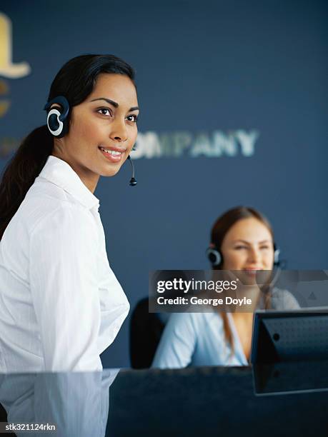 two businesswomen wearing headsets in an office - kommunikationsberuf stock-fotos und bilder