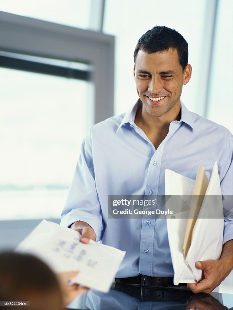 Handing Envelope Businessman Handing An Envelope To A Person In An Office High-Res Stock ...