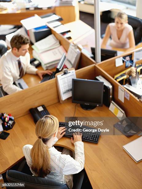 high angle view of a businessman and two businesswomen working in an office - maschio con gruppo di femmine foto e immagini stock