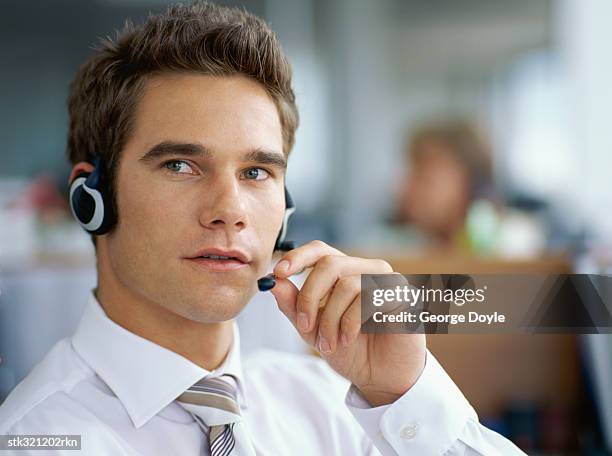 close-up of a businessman wearing a headset in an office - métier de la communication photos et images de collection