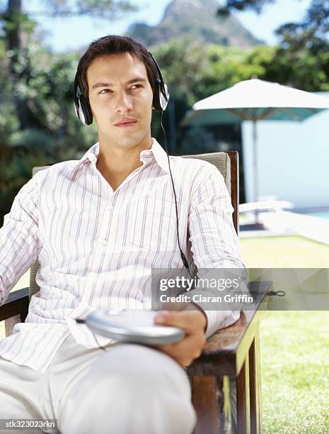 young man wearing headphones and listening to music - audiogerät stock-fotos und bilder