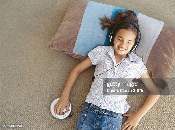 high angle view of a girl wearing headphones and listening to music - electrónica de audio fotografías e imágenes de stock
