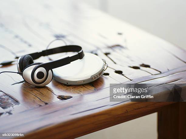headphones and a personal stereo on a wooden table - personal stereo stockfoto's en -beelden