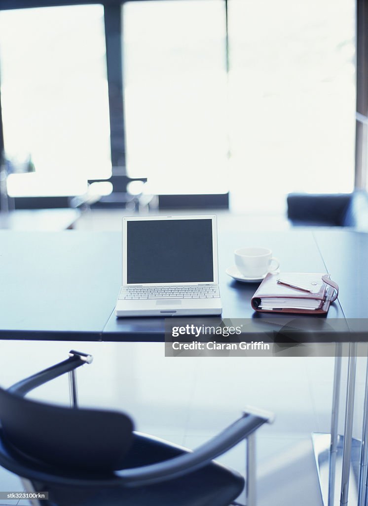 Open laptop and a personal organizer on an office table