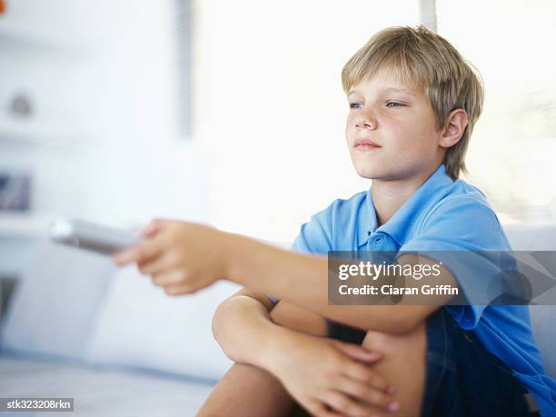 boy pointing a remote control - control photos et images de collection