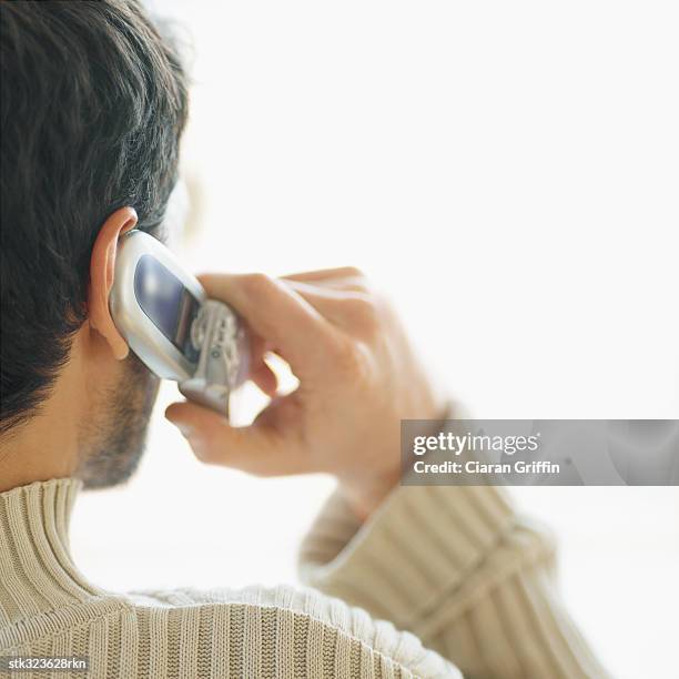 rear view of a mid adult man talking on a mobile phone - square neckline 個照片及圖片檔