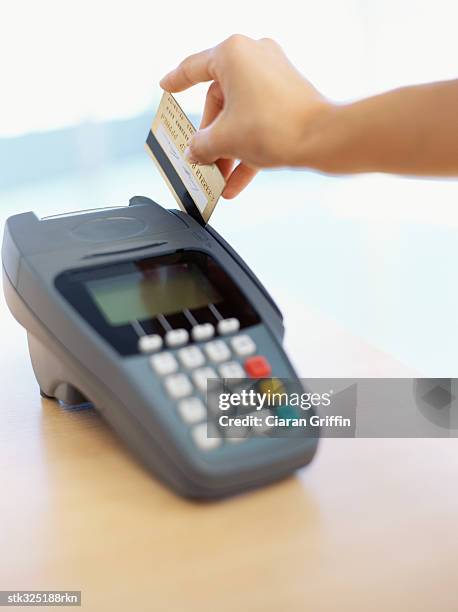 human hand swiping a credit card - equipamento de varejo - fotografias e filmes do acervo