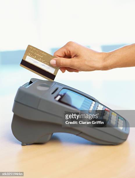 human hand swiping a credit card - equipamento de varejo - fotografias e filmes do acervo