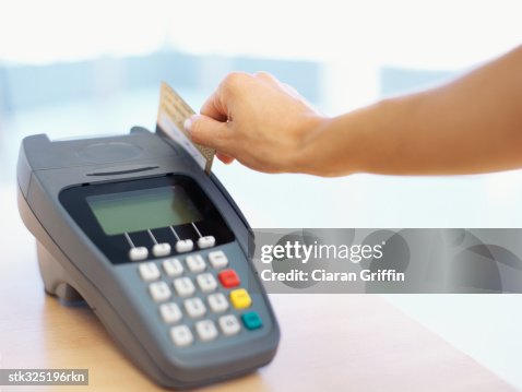 Closeup Of A Human Hand Swipping A Credit Card On A Credit Card Reader ...