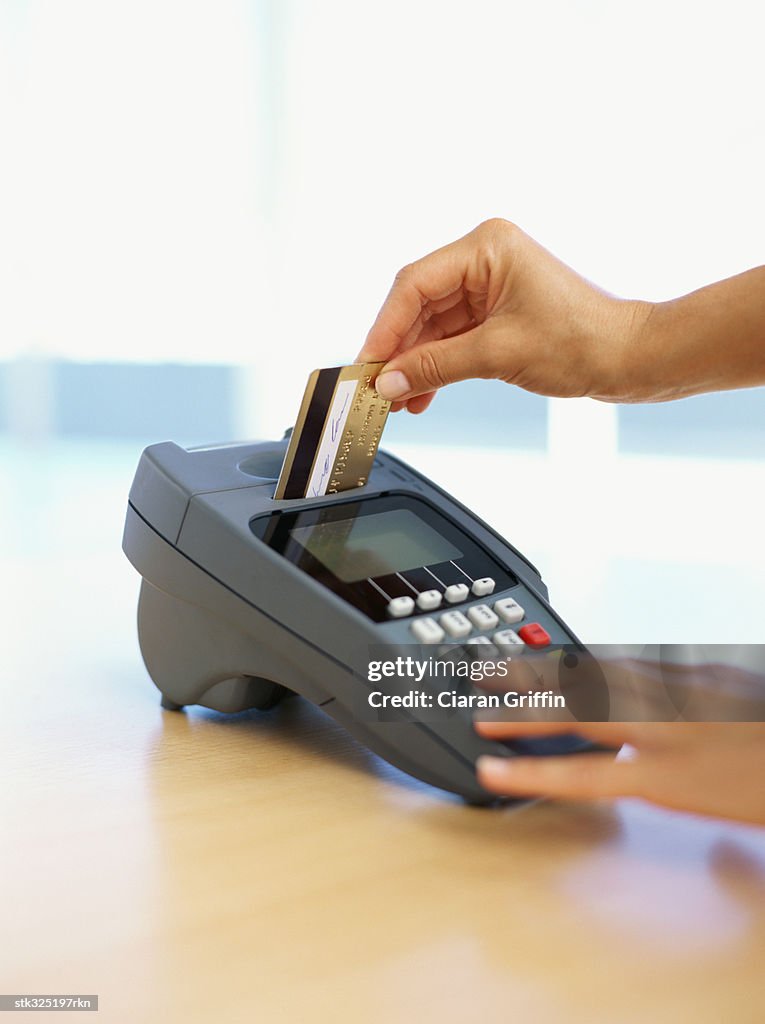 Human hand swiping a credit card