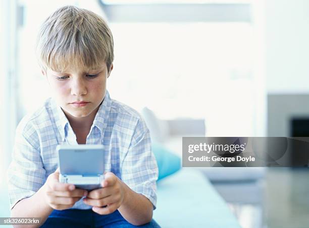 boy playing with a video game - recreational equipment stock pictures, royalty-free photos & images