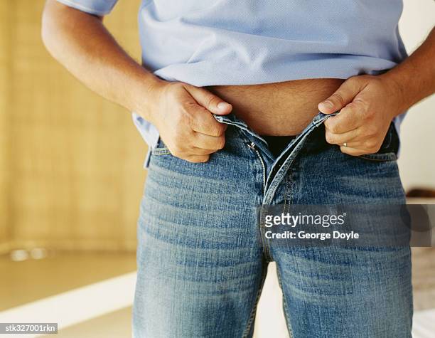 mid section view of a man buttoning his jeans - getting dressed stock pictures, royalty-free photos & images