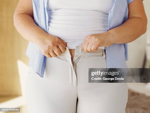 mid section view of a woman buttoning her pant - retail of amorepacific corp brands as south koreas biggest cosmetics makers revamps product lineup stockfoto's en -beelden