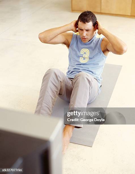 high angle view of young man exercising on the floor - exercise room stock pictures, royalty-free photos & images