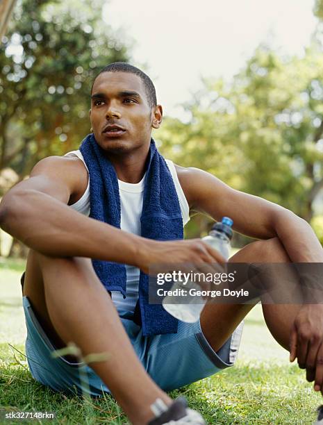 young man holding a water bottle in a park - adrienne bailon and gillette ask miami couples to kiss tell if they prefer stubble or smooth shaven stock pictures, royalty-free photos & images