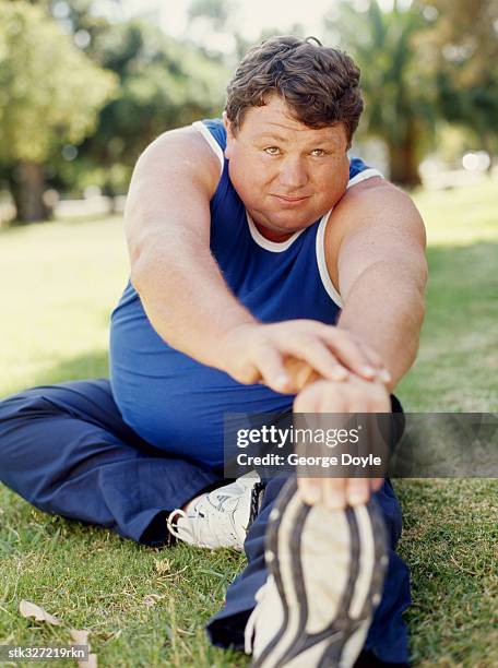 mid adult man exercising in a park - chubby teen stockfoto's en -beelden