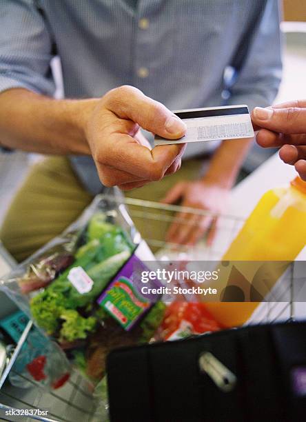 close-up of a person paying for groceries with a credit card - retail of amorepacific corp brands as south koreas biggest cosmetics makers revamps product lineup stockfoto's en -beelden