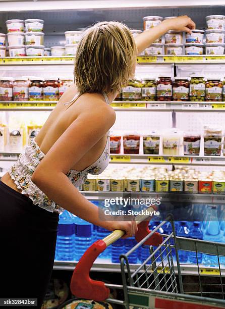 view of a young woman with shopping cart reaching out for a product - retail of amorepacific corp brands as south koreas biggest cosmetics makers revamps product lineup stockfoto's en -beelden