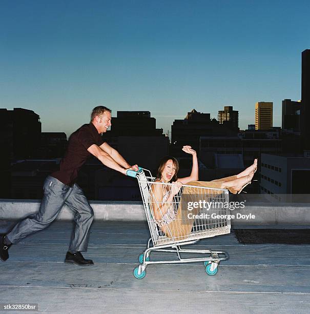 view of a young man pushing a young woman in a shopping cart - retail of amorepacific corp brands as south koreas biggest cosmetics makers revamps product lineup stockfoto's en -beelden