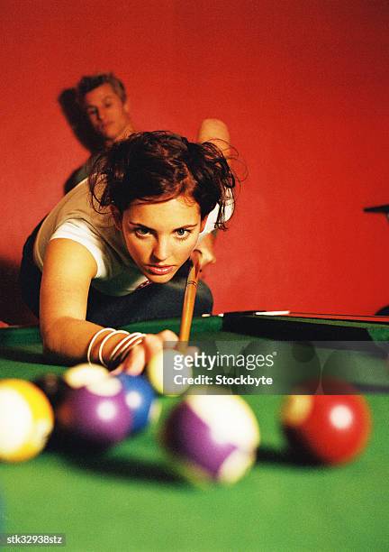 close-up of a young woman leaning forward to play a shot of pool - proceso cruzado fotografías e imágenes de stock