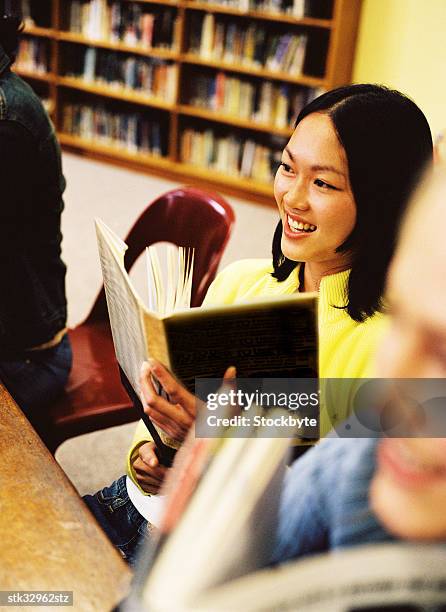 view of a young woman reading a book - university of california students protest 32 percent fee hike stockfoto's en -beelden