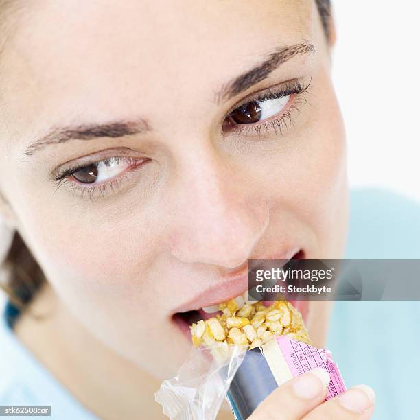 woman eating a candy bar - bar ストックフォトと画像